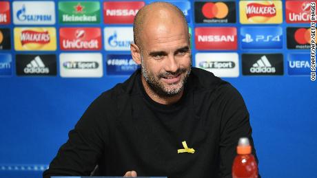 Manchester City's Spanish manager Pep Guardiola wears a yellow ribbon on his jumper, in support of those currently in detention in Catalonia, during a press conference.