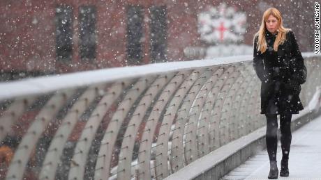 A commuter crosses London&#39;s Millennium Bridge over the Thames on Monday.