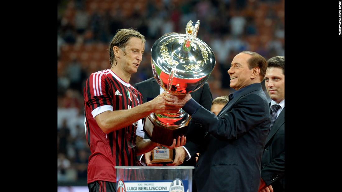 Berlusconi hands the Berlusconi Trophy to AC Milan&#39;s Massimo Ambrosini in August 2011. The trophy is awarded annually to the winner of a friendly football match in Milan.