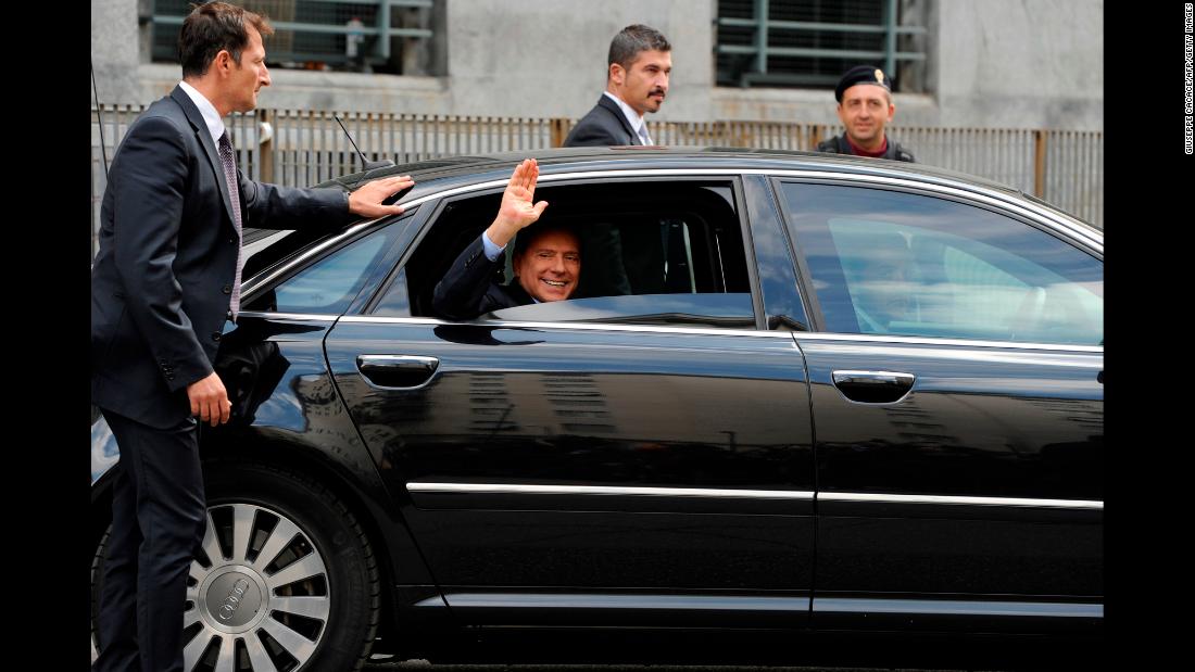 Berlusconi waves as he leaves a court in Milan in September 2011.