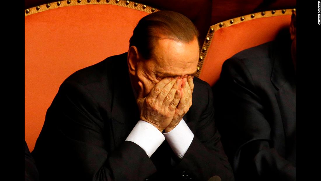 Berlusconi rubs his eyes after delivering a speech in Rome in October 2013. That month, Berlusconi was preliminarily indicted on allegations he bribed a senator to support his party in 2006. He would be convicted in 2015 and banned from holding public office for five years.