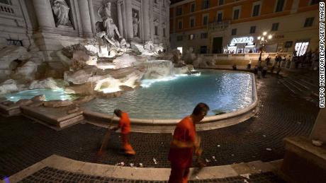 A worker with the municipal rubbish collection company cleans the floors of the Trevi Fountain in August 2016.