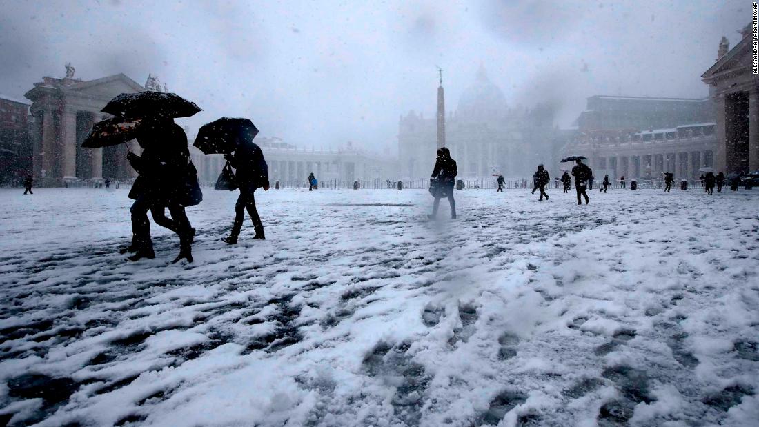 I romani camminano nella neve in Piazza San Pietro il lunedì. 
