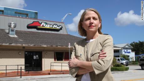 Mary Barzee Flores, now a candidate for Congress, stands outside the Pizza Hut where she was attacked as a teen.