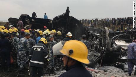 Rescuers survey the wreckage of the plane.  