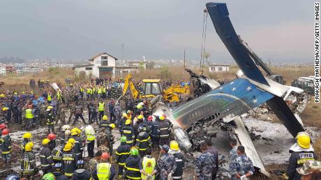 Nepali rescue workers gather around the debris of an airplane that crashed near the international airport in Kathmandu on March 12, 2018.
At least 40 people were killed and 23 injured when a Bangladeshi passenger plane crashed near Kathmandu airport March 12, an official said. &quot;Thirty-one people died at the spot and nine died at two hospitals in Kathmandu,&quot; police spokesman Manoj Neupane told AFP, adding another 23 were injured. There were 67 passengers and four crew on board the US-Bangla Airlines plane from Dhaka.

 / AFP PHOTO / Prakash MATHEMA        (Photo credit should read PRAKASH MATHEMA/AFP/Getty Images)