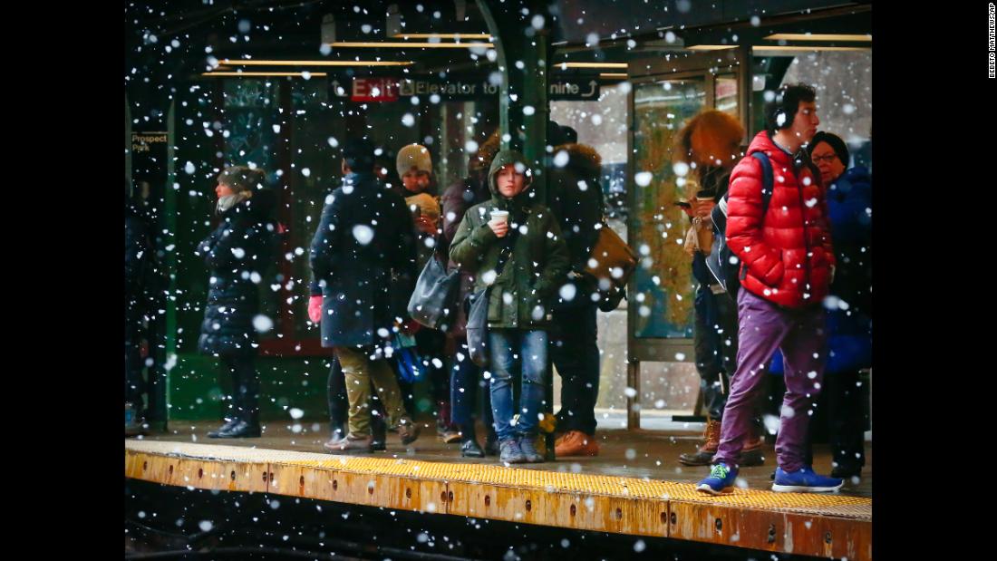 Commuters are sheltered from snowfall while they wait on a subway platform in New York City on March 13.