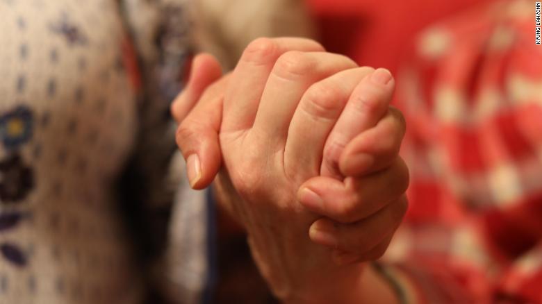 A Jewish woman clasps the hand of an undocumented woman whom she is sheltering.