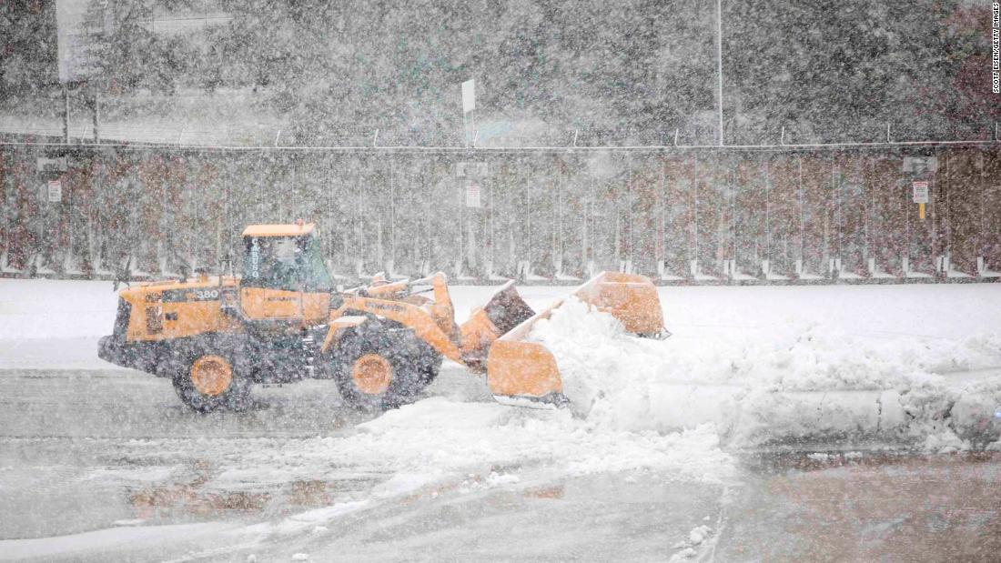 A snow plow clears a taxiway at Logan International Airport in Boston.