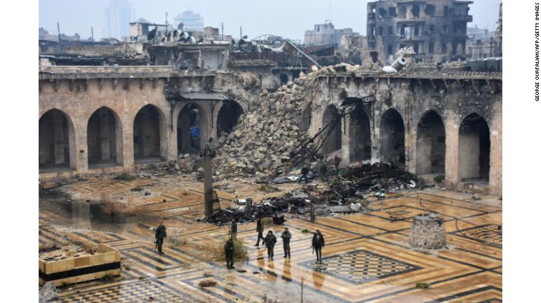  Syrian pro-government forces walking in the ancient Umayyad mosque in the old city of Aleppo after they captured the area. 