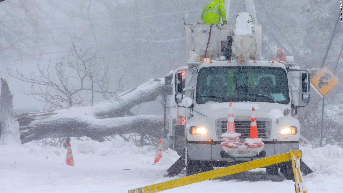 Workers remove a fallen tree from a road in Norwell, Massachusetts, on March 13.