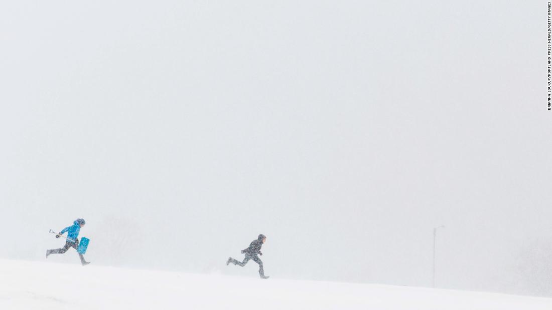 People run through heavy snow in Portland, Maine, on March 13.