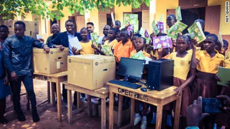 Richard Appiah Akoto (second from left) and his students show off their new computers and books.