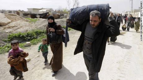 Syrians from rebel-held Eastern Ghouta arrive at the regime-held checkpoint in Adra, on the northeastern outskirts of Damascus, after escaping the enclave through a corridor opened by the government forces on March 15, 2018. 
Thousands of civilians poured out of Syria&#39;s Eastern Ghouta bringing the government closer to retaking the rebel enclave near the capital as the brutal war enters its eighth year.  / AFP PHOTO / LOUAI BESHARA        (Photo credit should read LOUAI BESHARA/AFP/Getty Images)