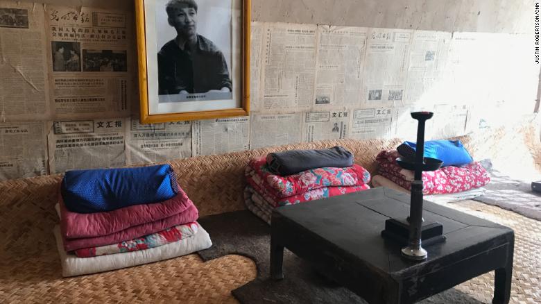 A photo of a youthful Xi as well as old newspapers adorn the wall above his old shared bed in a &quot;cave house.&quot;