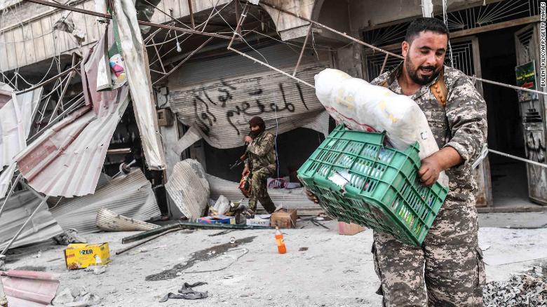 Fighters loot shops after seizing control of Afrin from Kurdish forces on Sunday.