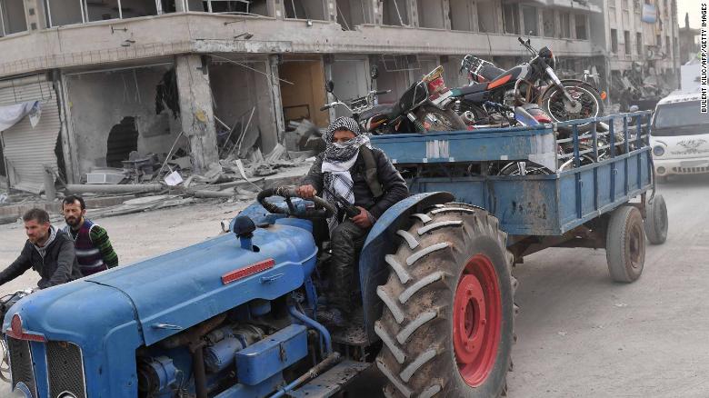 A fighter tows looted items in a trailer.