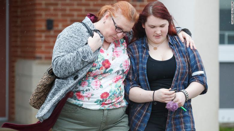 A mother walks with her daughter, a student from Great Mills High School, as she picks her up from a nearby high school in Leonardtown, Maryland, on Tuesday.