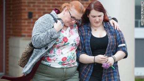 A mother walks with her daughter, a student from Great Mills High School, as she picks her up from a nearby high school in Leonardtown, Maryland, on Tuesday.