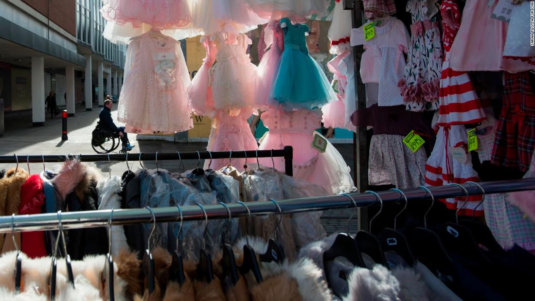 Children&#39;s ruffled dresses hang from a stall in Romford Market.