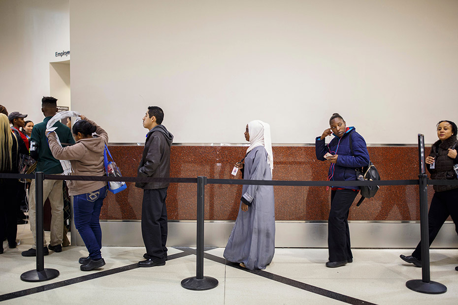 The commotion of the airport frightened Batulo at first. Now she&#39;s familiar with the routines of this place, like the security line where she waits with other employees. (Melissa Golden/Redux for CNN)