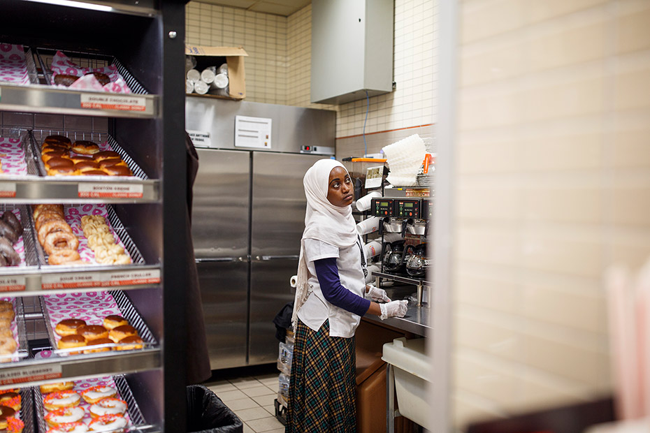 Batulo prepares to make a fresh pot of coffee at an airport Dunkin&#39; Donuts, where she landed a job shortly after arriving in the United States. (Melissa Golden/Redux for CNN)