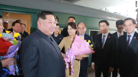 Kim Jong Un and his wife Ri Sol Ju are seen outside what appears to be the Kim&#39;s family train car in Beijing in a photograph released by North Korean state media. Kim arrived in China by train on March 25 and crossed the border back to Pyongyang on March 28.