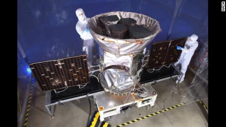 Technicians help prepare the spacecraft for its mission.
