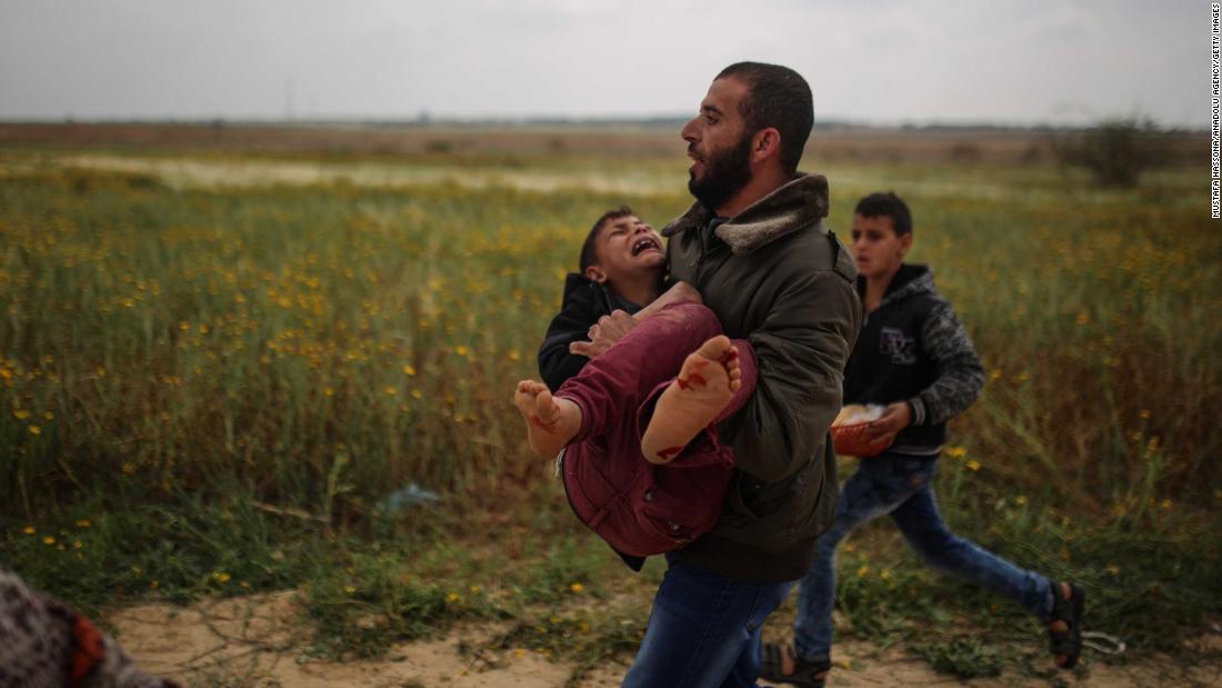 A Palestinian man carries a wounded boy away from protests in Gaza on Friday. 