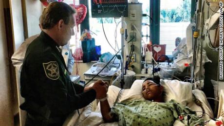 This image made available by the Broward County Sheriff&#39;s Office on Sunday, Feb. 18, 2018, shows Sheriff Scott Israel, holding the hand of Anthony Borges, 15, a student at Marjory Stoneman Douglas High School. The teenager was shot five times during the massacre on Valentine&#39;s Day that killed 17 students. Borges is being credited with saving the lives of at least 20 other students. (Broward County Sheriff&#39;s Office via AP)