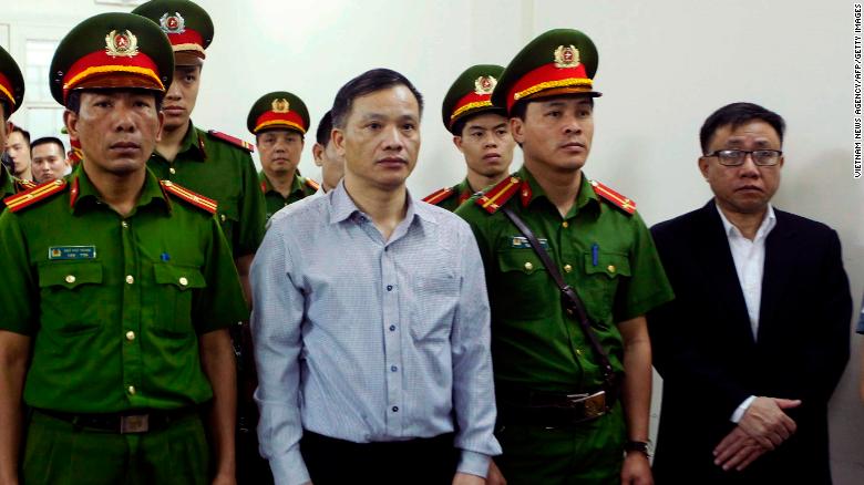 Vietnamese lawyer Nguyen Van Dai (center) stands in a courtroom during his trial with other political activists in Hanoi on April 5, 2018.