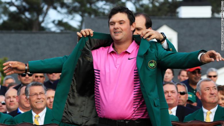 Patrick Reed  is awarded the Green Jacket by 2017 winner Sergio Garcia of Spain after winning the Masters at Augusta.