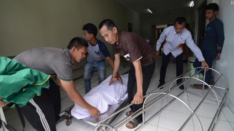 At a hospital in Cicalengka, West Java, family members on Monday move the body of a relative who died from drinking poisonous bootleg liquor.