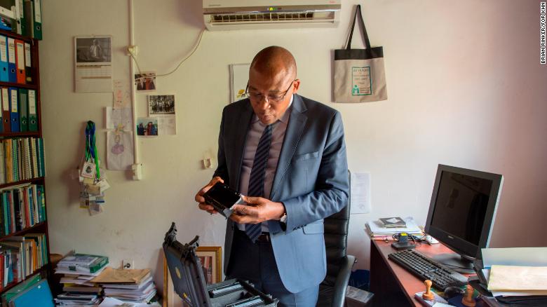 Dr. Joseph Kamgno examines a new version of a cellphone-based microscope in his research facility in Yaoundé, Cameroon.