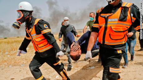 Palestinian paramedics evacuate an injured protester on April 13, 2018.