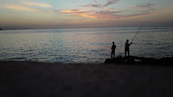 Cubans fish off Havana's Malecón seawall at sunset. The wall has been used during the years by Cubans launching small boats to attempt the dangerous journey across the Straits of Florida to the United States. Cubans who reached the US were allowed to stay there under the so-called "wet foot, dry foot" law that gave Cubans special immigration status. But in 2017, President Obama ended that policy and Cubans who reach the US are now being sent back to the island.