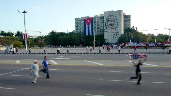 A protester carrying an American flag runs through Havana's revolution square on May Day 2017 ahead of a government-sponsored parade as plainclothes Cuban security agents try to catch him. International human rights groups criticize the Cuban government for repressing internal dissent. Cuban officials say the island's dissidents are "mercenaries" paid by Washington to stir up trouble.