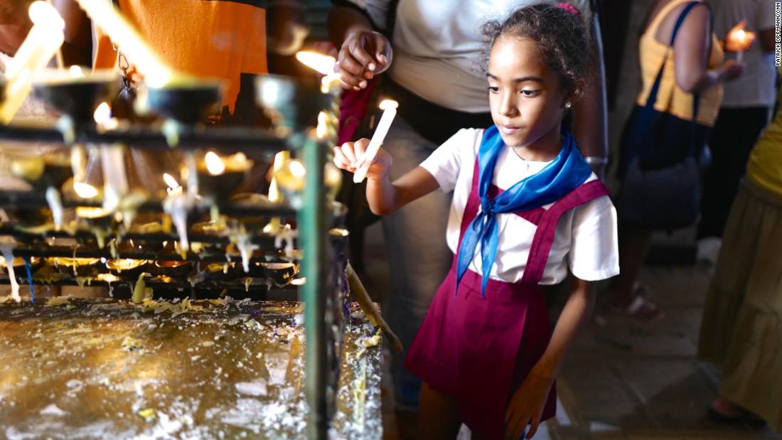 A young Cuban girl in her &quot;pioneer&quot; school uniform lights a candle at a Havana church days before the 2015 visit of Pope Francis to Cuba. Religion was all but banned following the Cuban revolution, and Catholics in particular faced government discrimination for openly practicing their faith. Over the last 20 years, the Cuban government has slowly eased restrictions on religion. In 2015, Raul Castro, a longtime atheist, said meeting the Pope made him consider returning to the Catholic church.