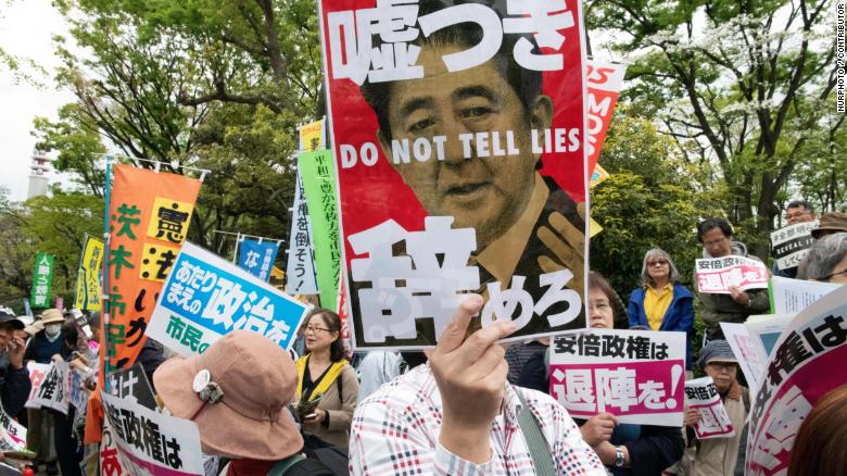 A protester holds a placard during a demonstration against Japan&#39;s Prime Minister Shinzo Abe on April 14, 2018.