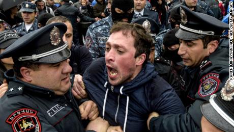 Armenian policemen detain an opposition supporter during a rally in Yerevan on April 21.