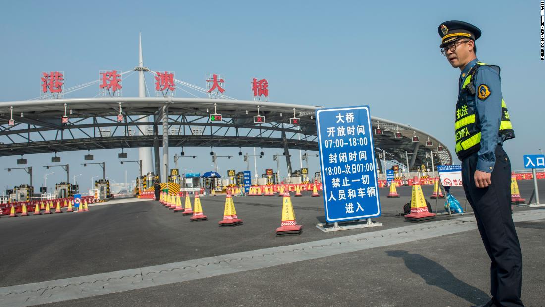 A guard stands in front of toll booths at the Zhuhai entrance to the Hong Kong-Zhuhai-Macau Bridge.