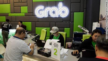 Employees attend to customers in the GrabCar division of Grab&#39;s office in Midview City in Singapore, on Wednesday, Oct. 19, 2016. Grab is riding a Southeast Asian ride-hailing arena with some 620 million people, forecast to grow more than five times to $13 billion by 2025. Photographer: Ore Huiying/Bloomberg via Getty Images