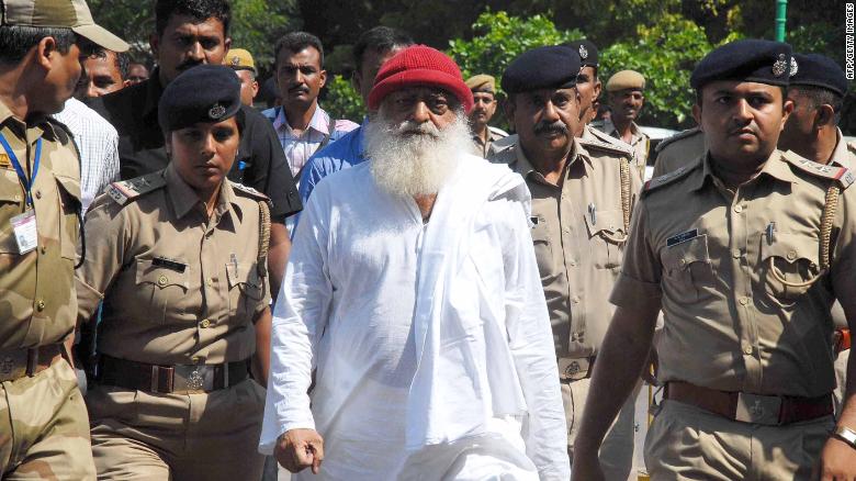 (FILES) In this file photo taken on October 14, 2013 Indian spiritual guru Asaram Bapu (C), accused of sexually assaulting a minor, is escorted by Gujarat state police in Jodhpur.
An Indian guru with millions of followers is in court in Jodhpur on April 25, 2018 accused of raping a teenage devotee on the pretext of ridding her of evil spirits. / AFP PHOTO / --/AFP/Getty Images