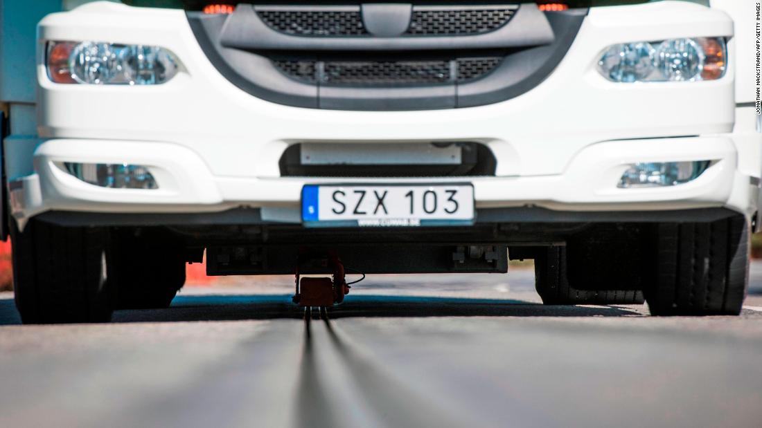 When vehicles approach the track, a sensor from the car or truck detects the electrified rail and a movable arm from underneath the vehicle lowers and inserts into the rail.