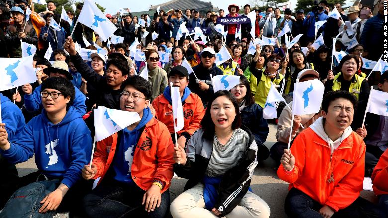 South Koreans react while watching a screen reporting the Inter Korean Summit on April 27 in Paju.