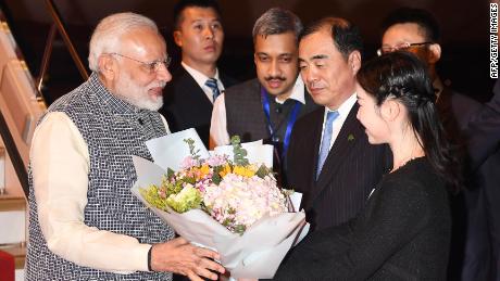 Indian Prime Minister Narendra Modi, left, receives a bunch of flowers after arriving in Wuhan in China&#39;s central Hubei province on April 27, 2018.
