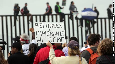 Pro-migrant caravan demonstrators rally at the US-Mexico border on April 29 in San Diego.