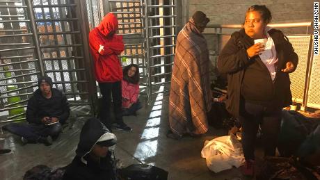 Migrants wait at the US-Mexico border to have their asylum claims processed. America lies on the other side of the turnstiles.