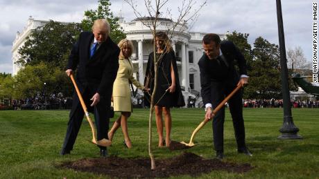 US President Donald Trump and French President Emmanuel Macron plant a tree watched by Trump&#39;s wfe Melania and Macron&#39;s wife Brigitte on the grounds of the White House April 23, 2018 in Washington,DC. - The tree, a gift from French President Macron, comes from Belleau Woods, near the Marne River in France, where in June 1918 US forces suffered 9,777 casualties, including 1,811 killed in the Belleau Wood battle during World War I. (Photo by JIM WATSON / AFP)        (Photo credit should read JIM WATSON/AFP/Getty Images)