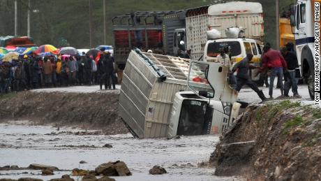 A man climbs off a truck that was washed off a road by flash floods in Isinya, about 58 km southeast of Nairobi, on March 15, 2018. 